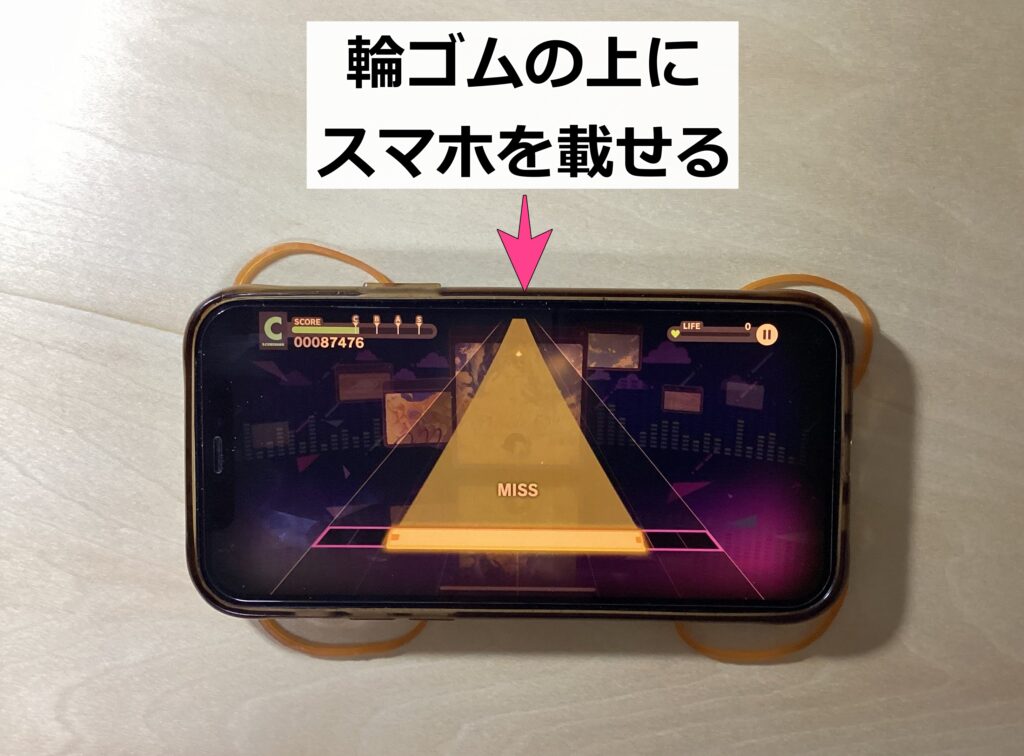 結論としてはスマホの四隅と中央に載るよう輪ゴムを1つずつ敷いて、その上にスマホを置くと、スマホがずれることなく音ゲーができますよ。